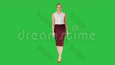 美丽的黑发女子商务办公风格<strong>时尚服装</strong>行走和微笑的镜头上的绿色屏幕